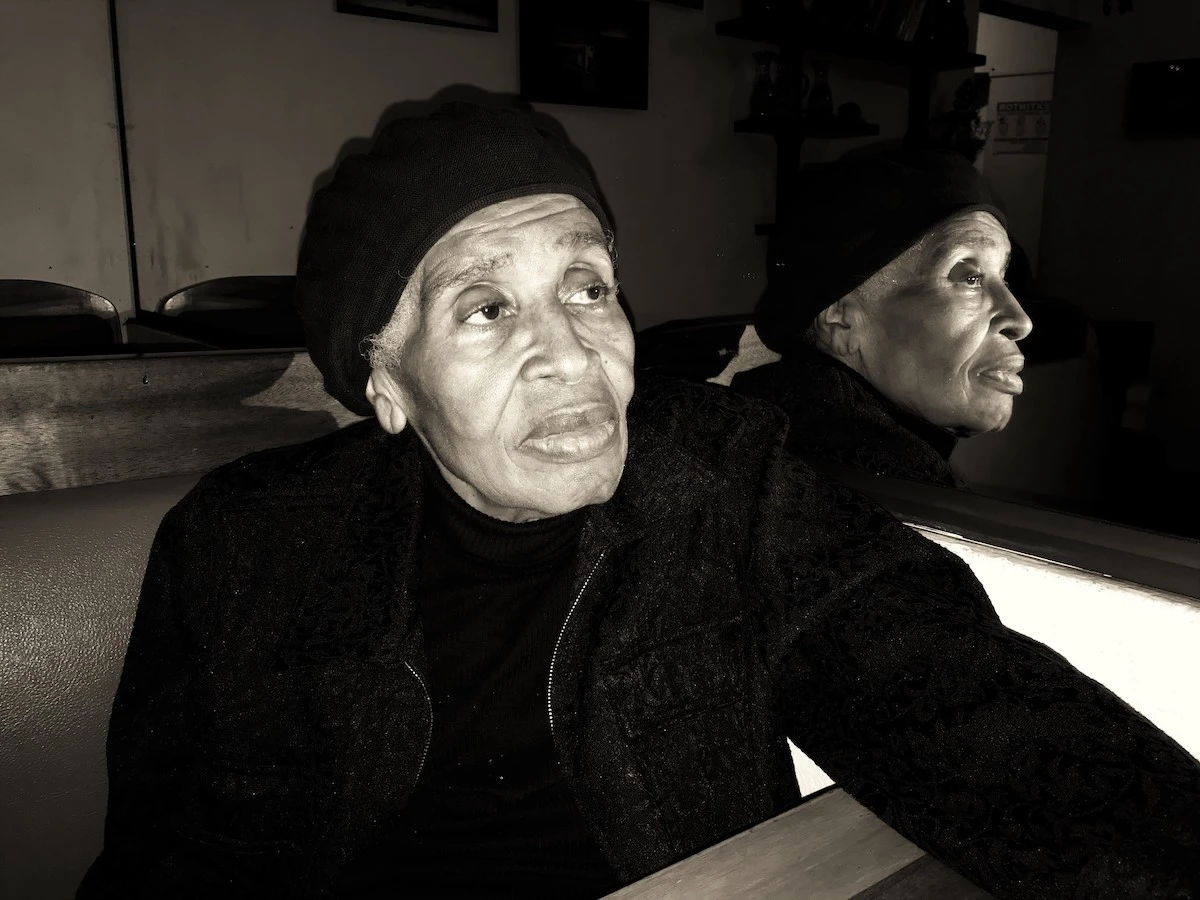 An elderly Black woman garbed entirely